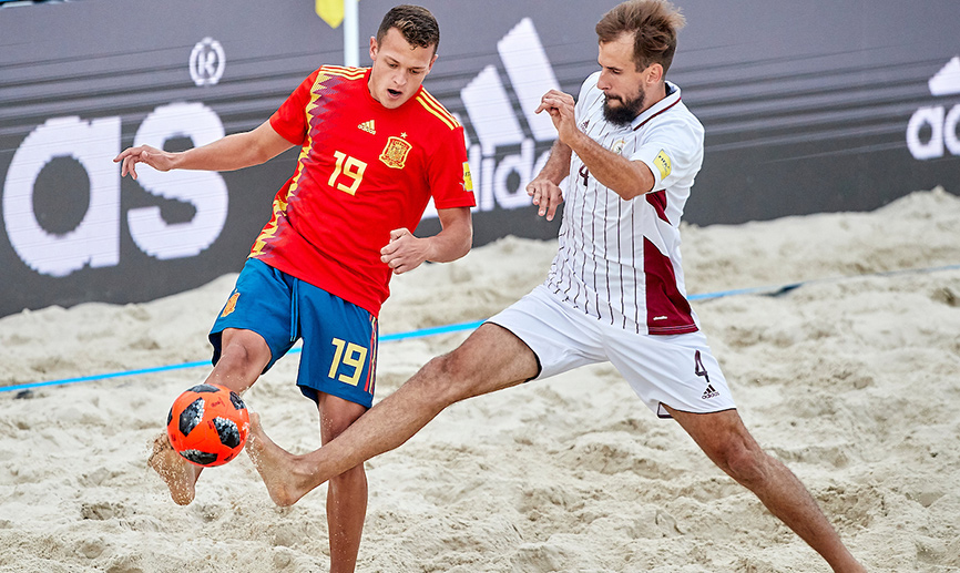 Domi pelea un balón ante un jugador letón