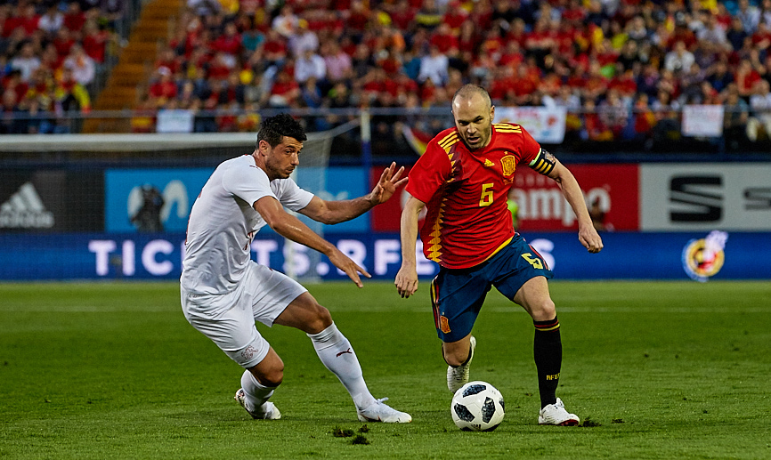 Iniesta controla un balón ante un rival