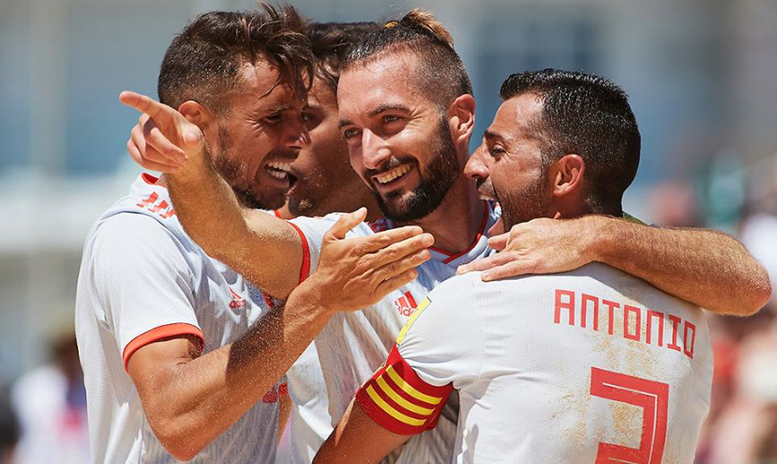 Los jugadores de fútbol playa celebran un gol