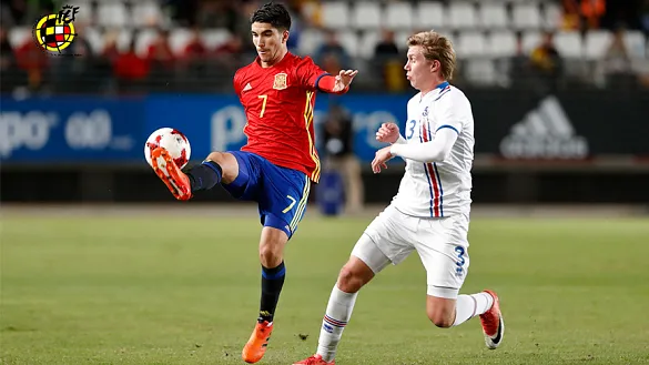 Carlos Soler disputando el balón con un jugador de Islandia
