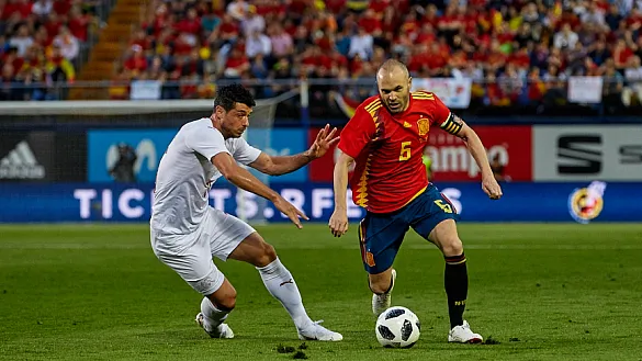 Iniesta controla un balón ante un rival