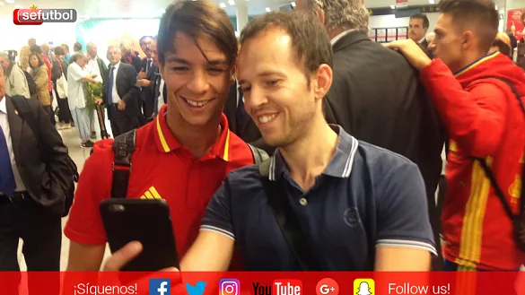 Óliver Torres se fotografía con un aficionado a la llegada de la Selección Sub-21