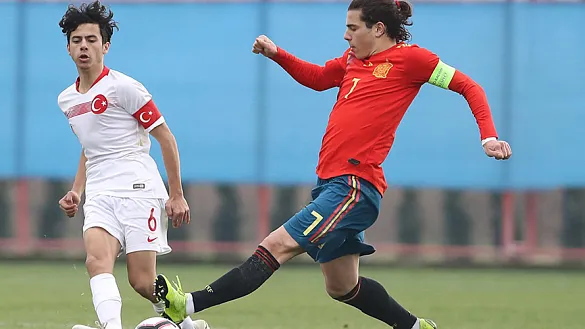 Dos jugadores de España y Turquía disputan un balón